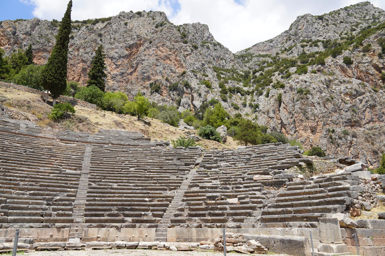 Explore the ancient ruins of the Greek theater at Delphi, nestled in the mountainous landscape.